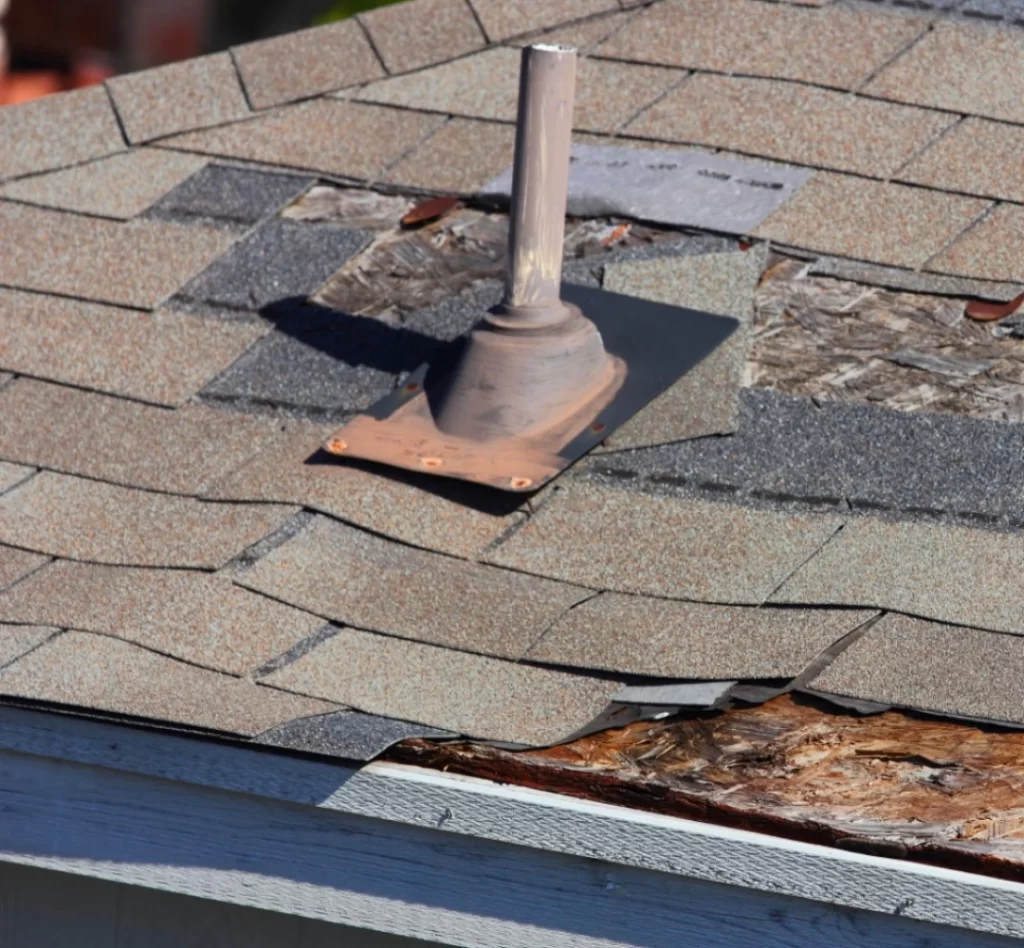 roof vent surrounded by damaged shingles in need of repair