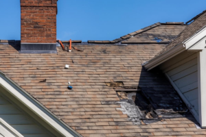 Damaged asphalt shingle roof with several missing and broken shingles.