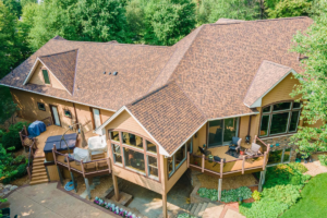 Large tan house with a brown shingled roof