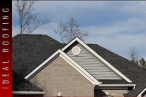Residential home with dark asphalt shingle roof and gable design, featuring vinyl siding and brick exterior, illustrating roof condition for repair or replacement evaluation.