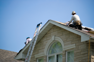 Technicians working on a residential roof; follow these roof inspection tips to ensure shingle longevity.