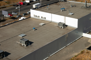 Large industrial flat roof with HVAC units; heavy equipment stress often shortens a commercial roof's life.