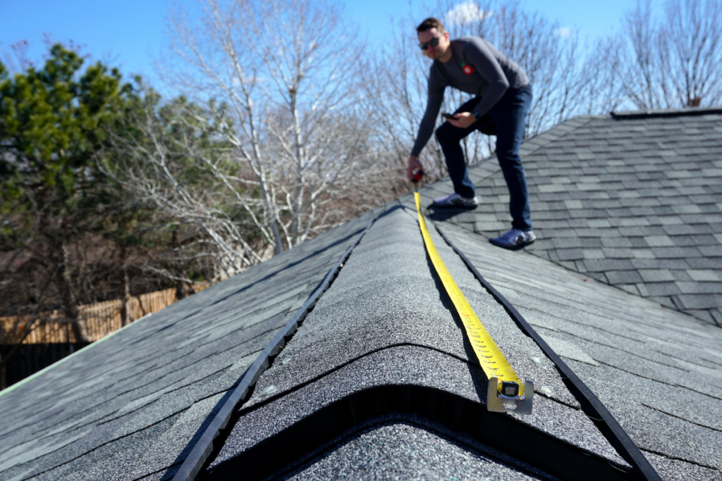 A roofer measuring the roof