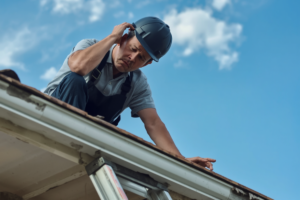 Roofer installing shingles on a residential roof, illustrating roofing warranties explained.